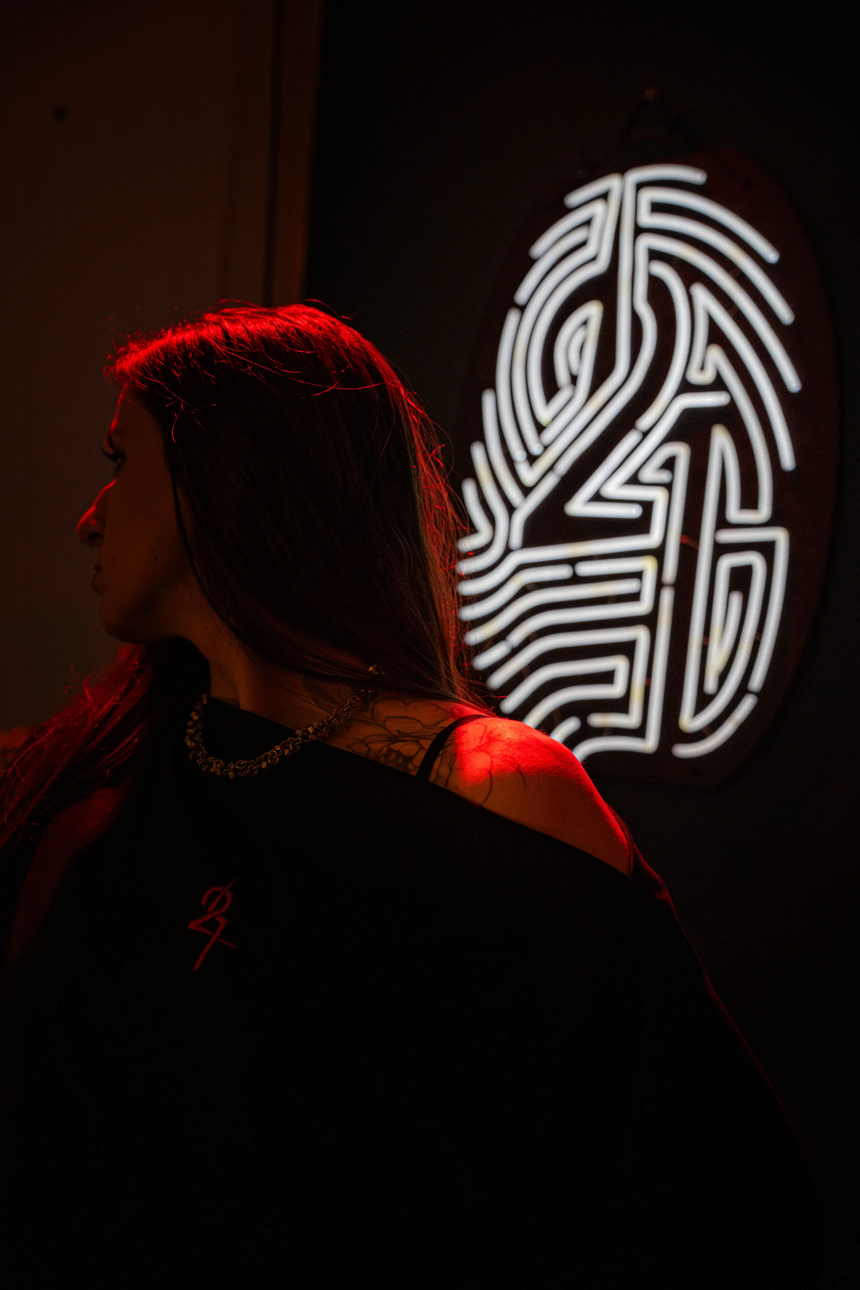 Red-lit profile beside the white 2H4S neon