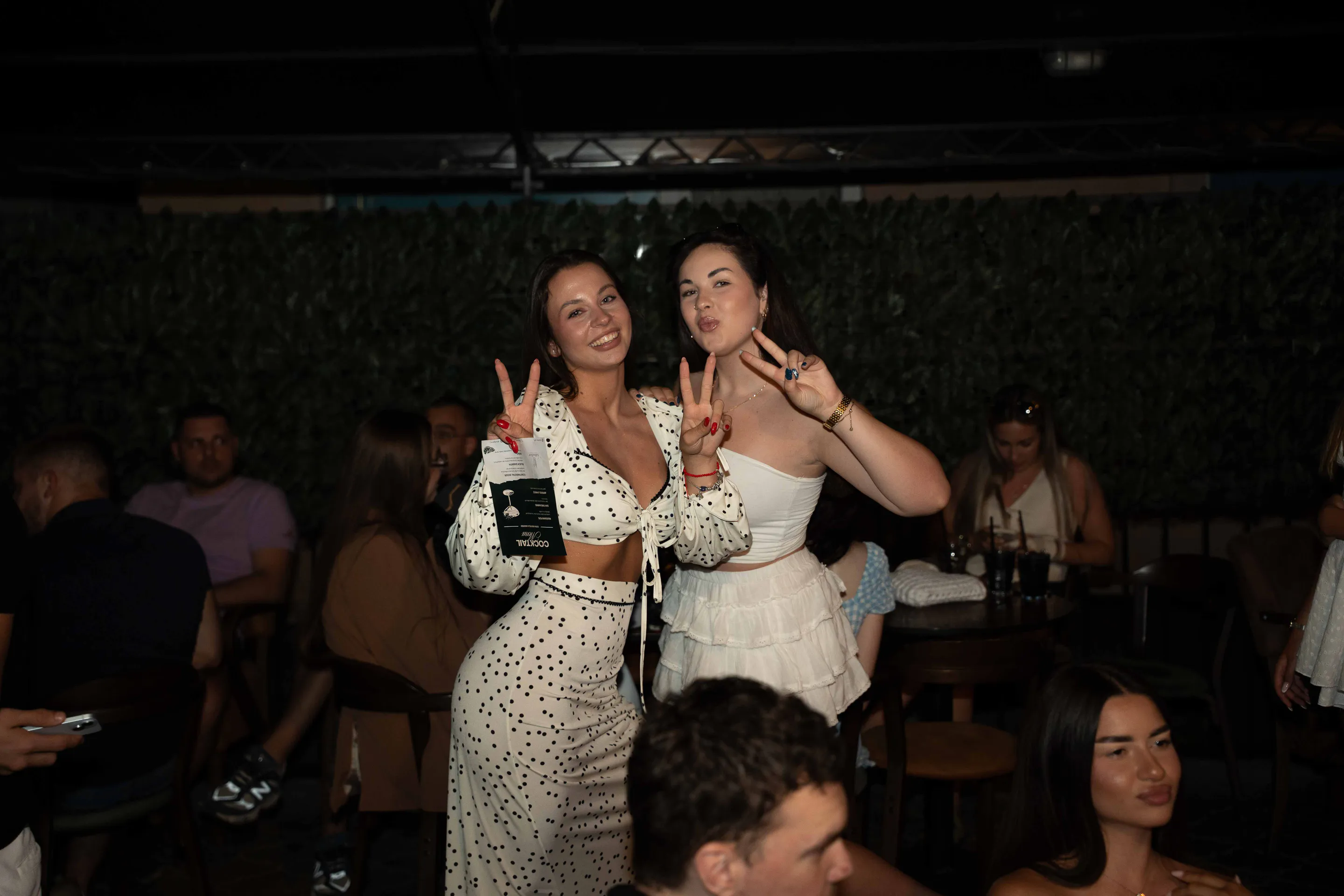 Two guests throwing peace signs across the terrace tables