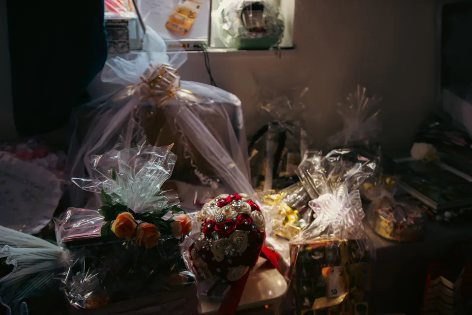 Gifts wrapped in tulle and cellophane crowding a low-lit table
