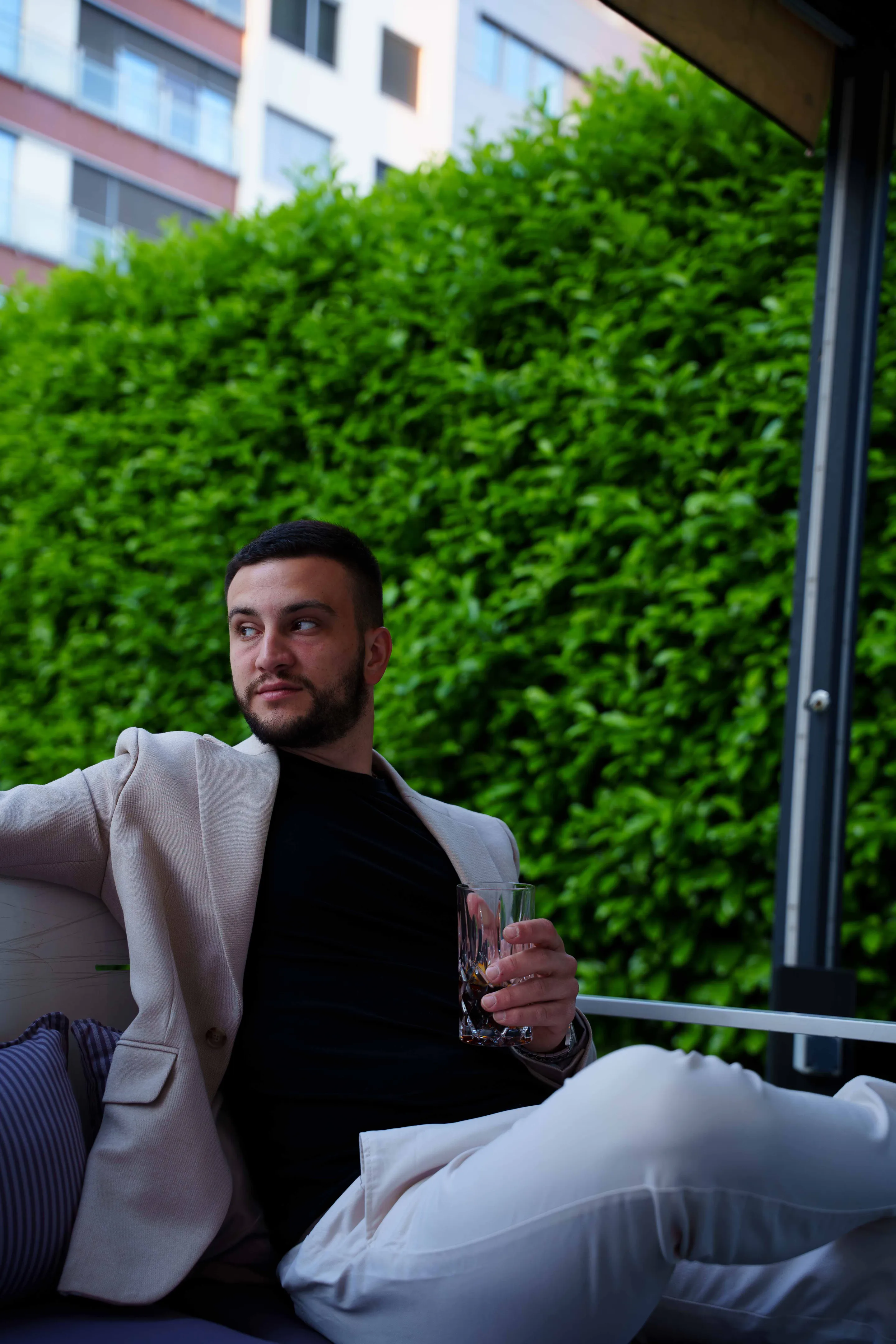 Leaning back on the terrace sofa, drink in hand
